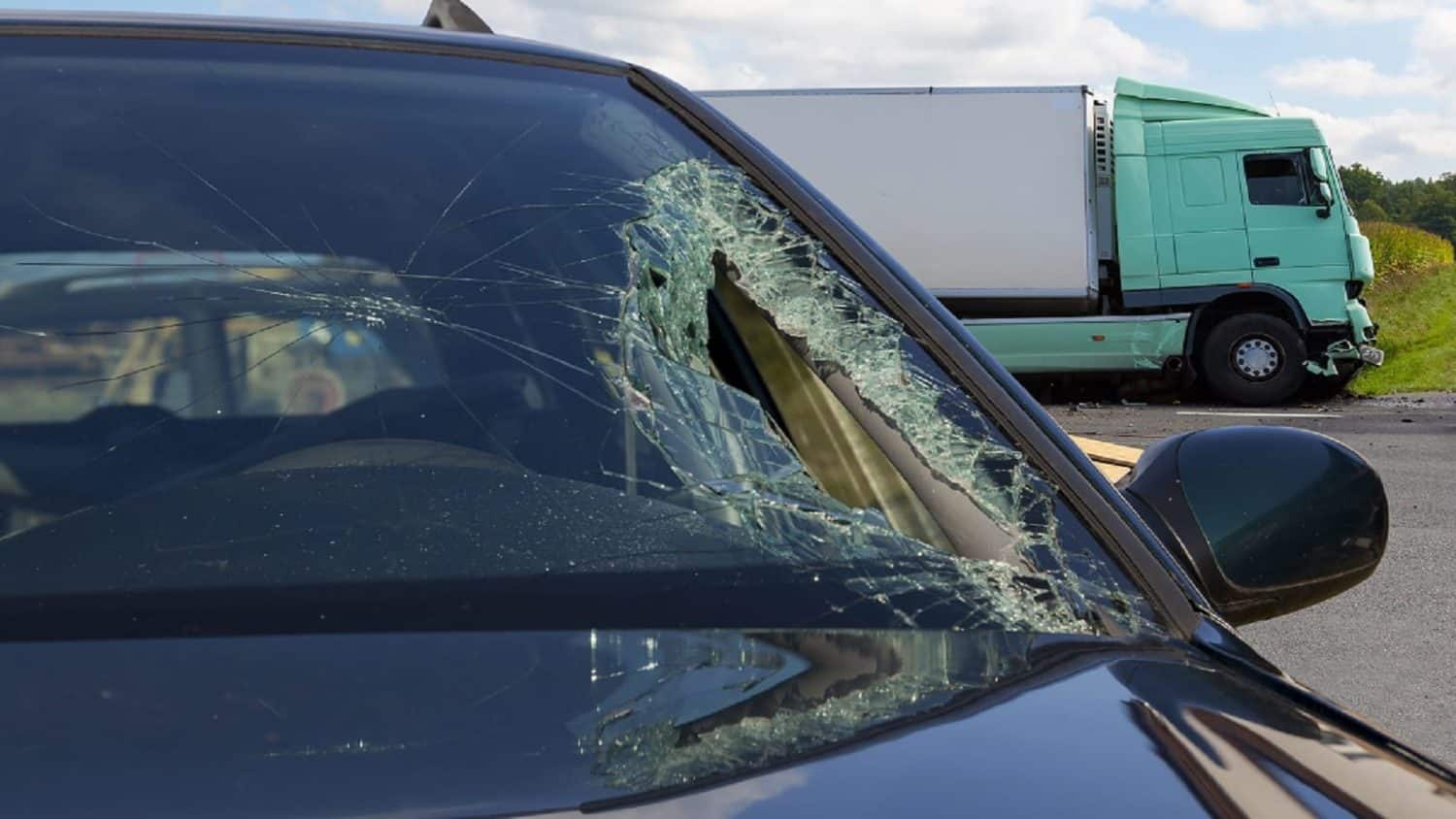 View of truck in an accident with car, broken glass